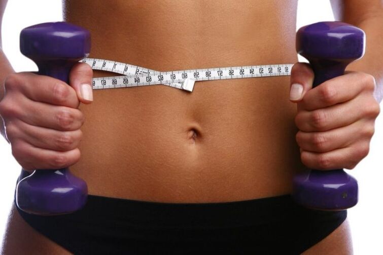 Manubri di fitness nelle mani di una ragazza di fito
